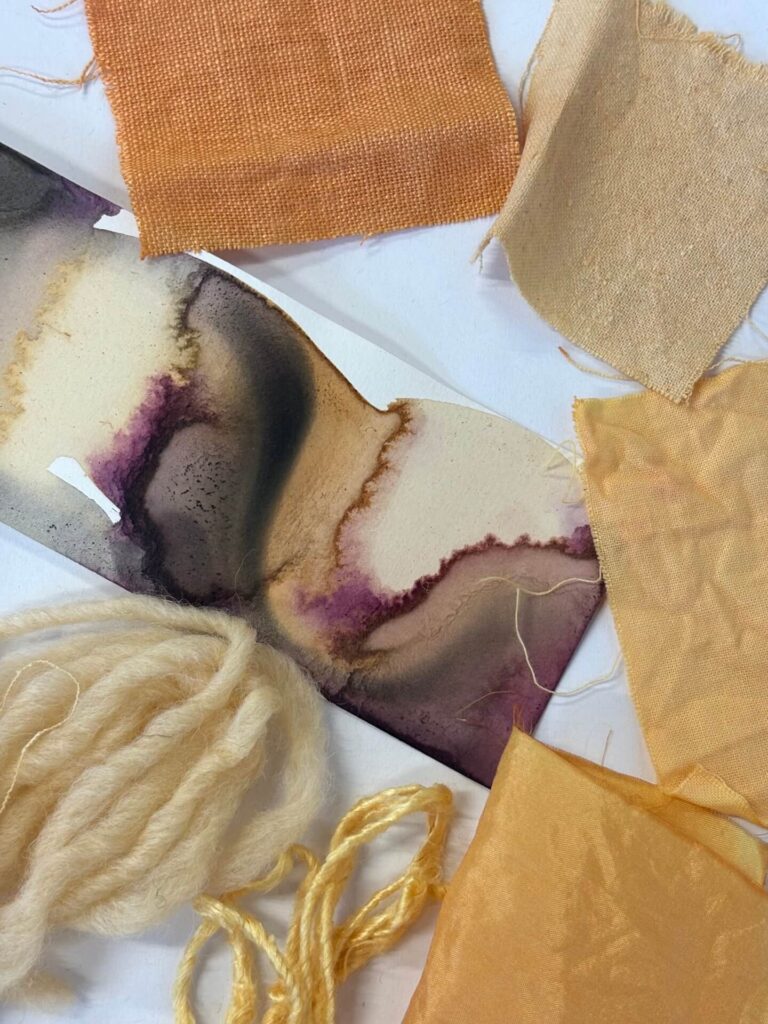 natural dye samples on fabric and wool in shades of yellow, orange and purple