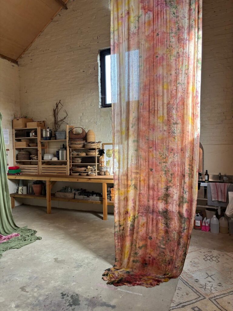 long translucent textile artwork by Michaela Lesayova hanging in a workshop